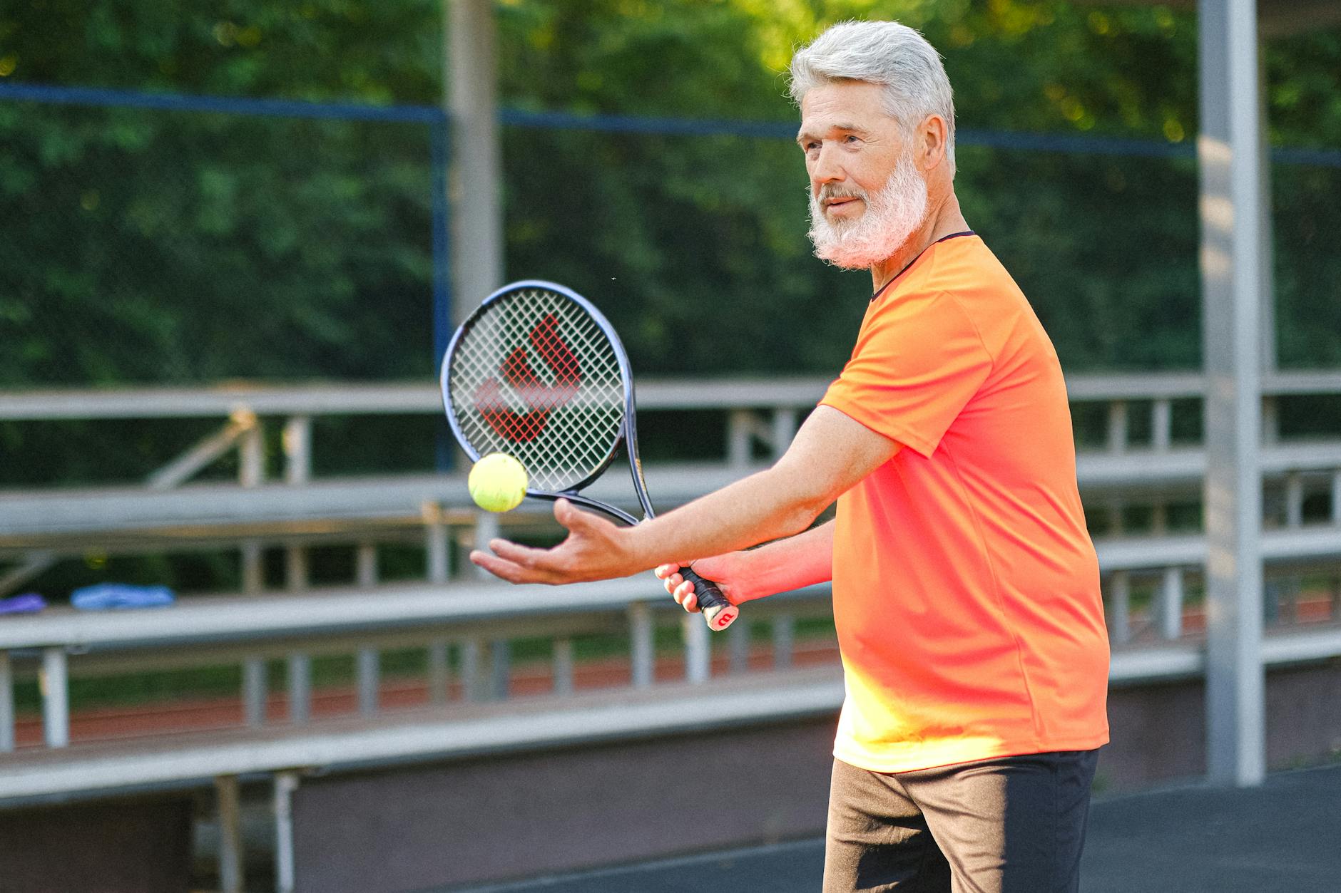 Adulto sujetando raqueta de tenis en pista